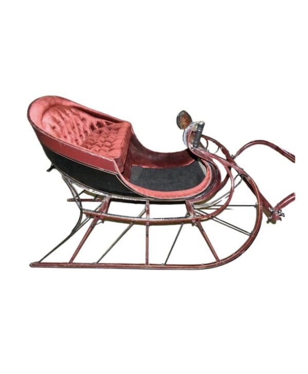 Antique red and black sleigh with upholstered seat.