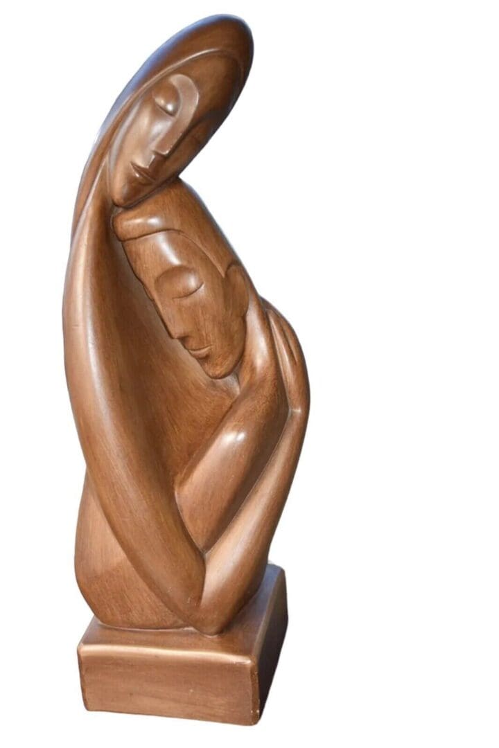 Wooden sculpture of two figures embracing.